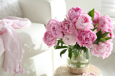 Bouquet of beautiful peonies on pouf indoors. Space for text