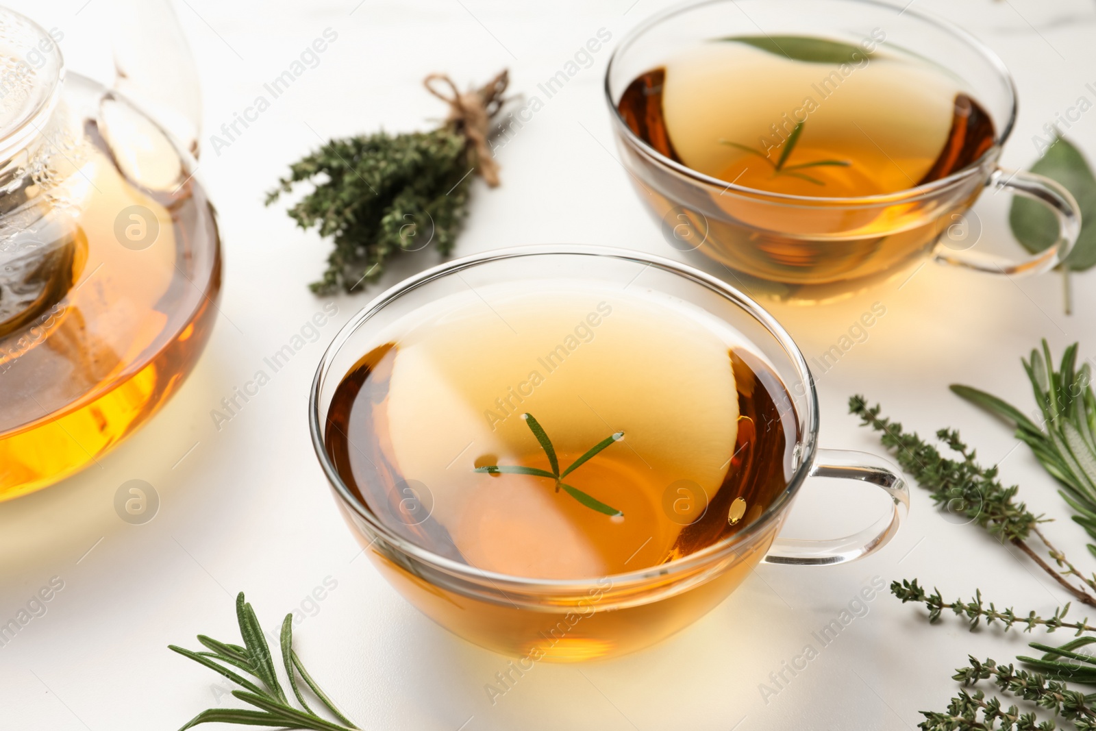 Photo of Aromatic herbal tea with thyme and rosemary on white marble table