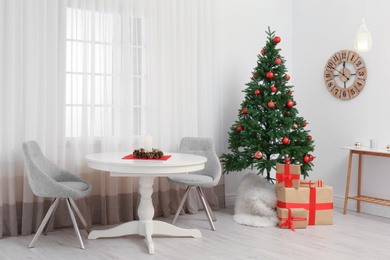 Photo of Stylish Christmas interior with fir tree, table and chairs