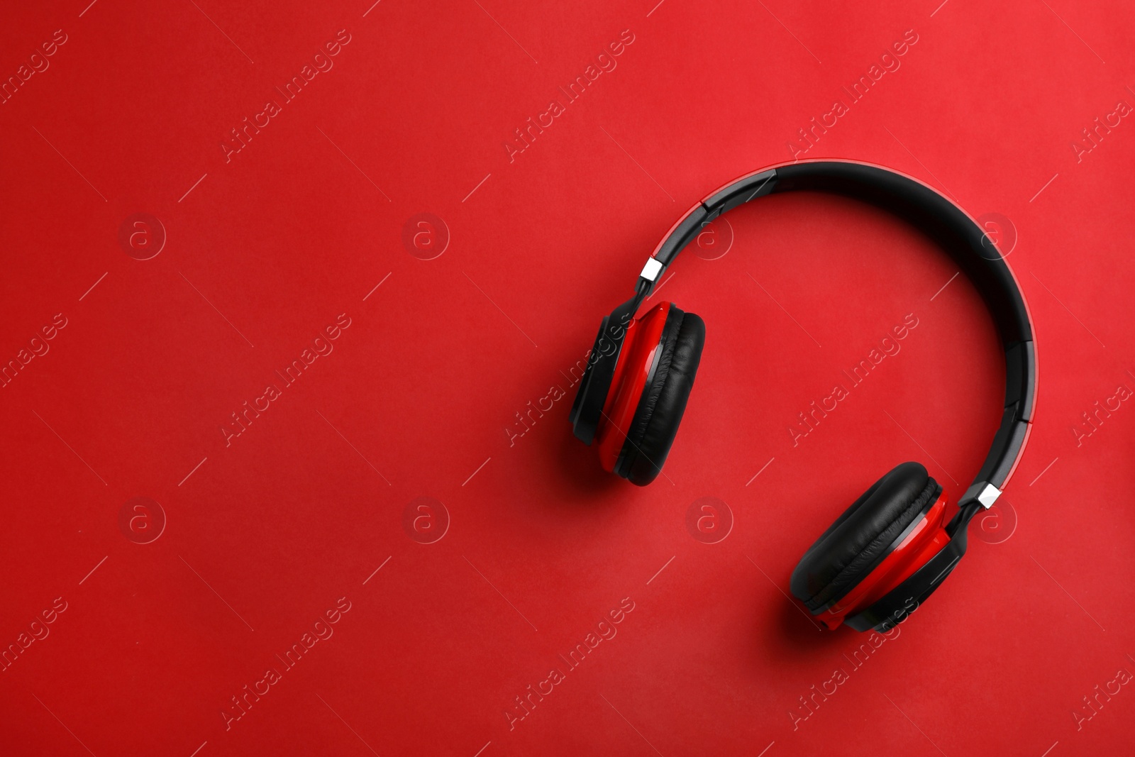 Photo of Wireless headphones on color background, top view. Space for text