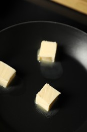 Photo of Melting butter in frying pan on table, closeup