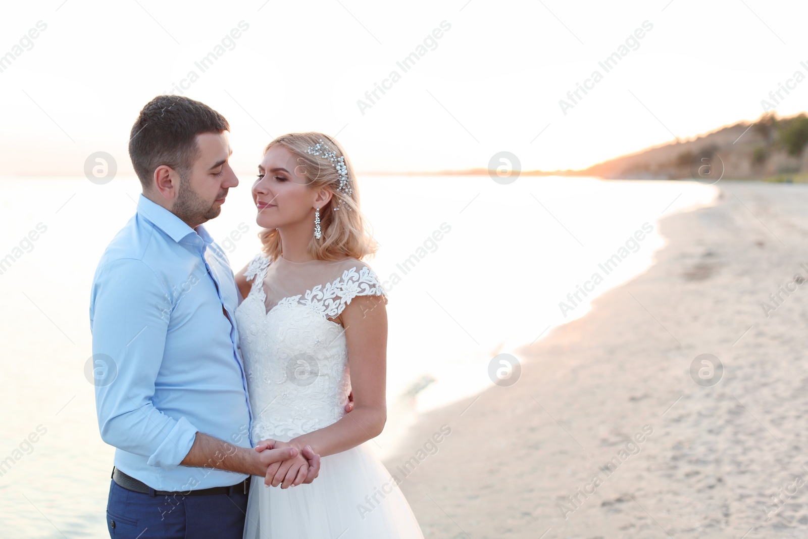 Photo of Wedding couple hugging on beach. Space for text