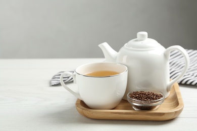 Buckwheat tea and granules on white wooden table. Space for text