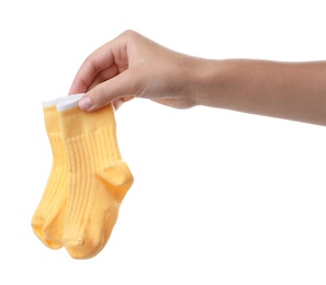 Woman holding pair of cute child socks on white background, closeup