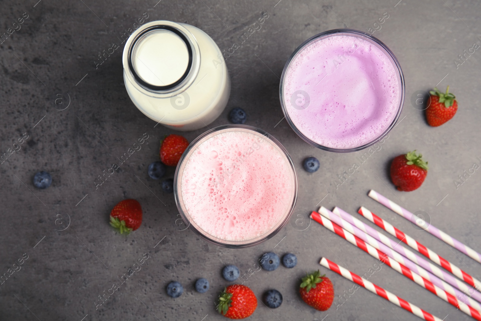 Photo of Flat lay composition with delicious milk shakes on grey background