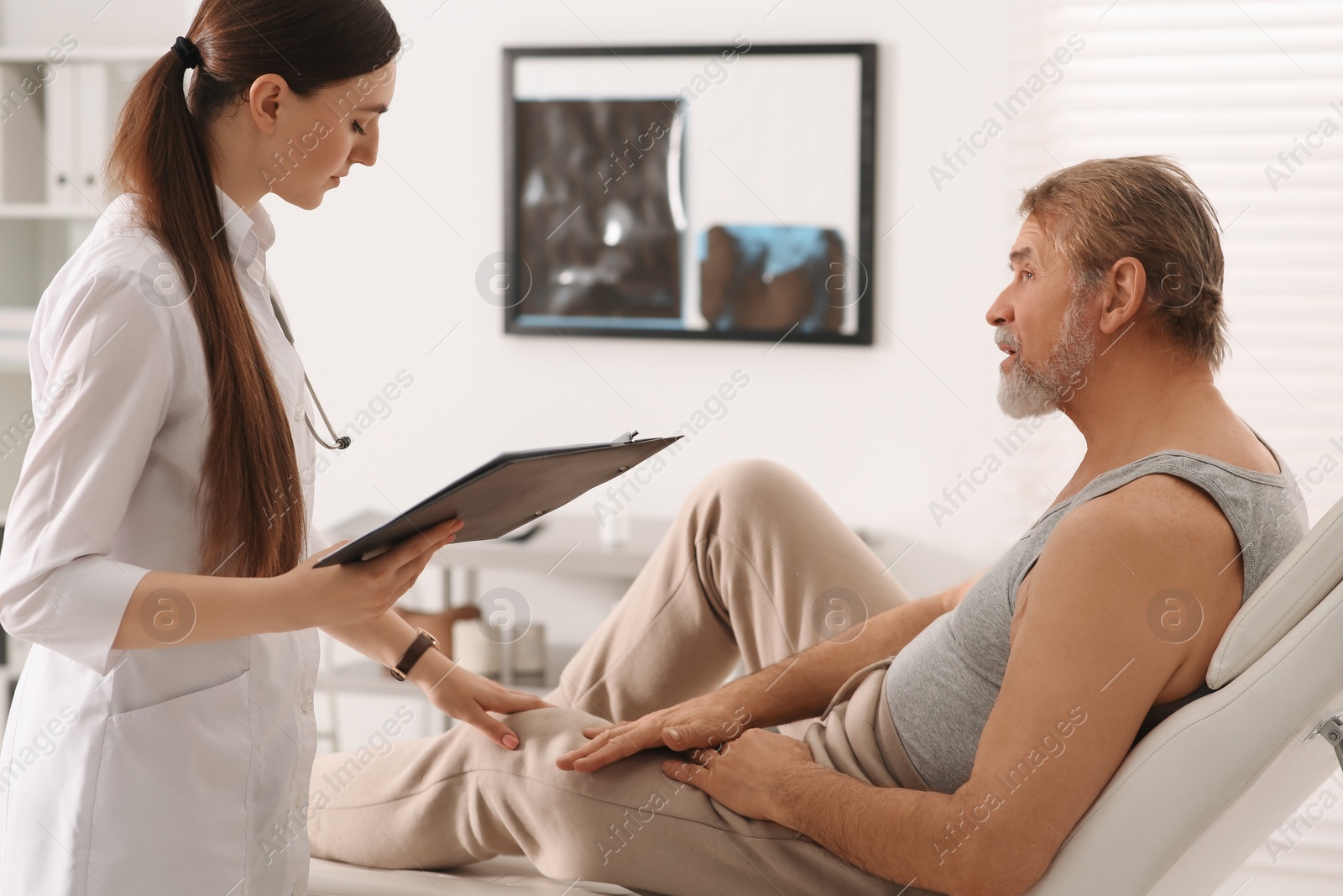 Photo of Professional female orthopedist consulting patient in clinic