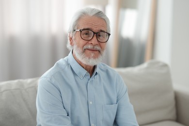 Photo of Portrait of grandpa with stylish glasses on sofa indoors