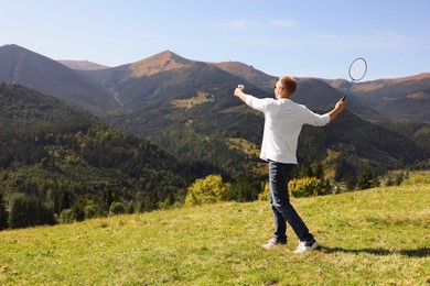 Photo of Man playing badminton in mountains on sunny day. Space for text