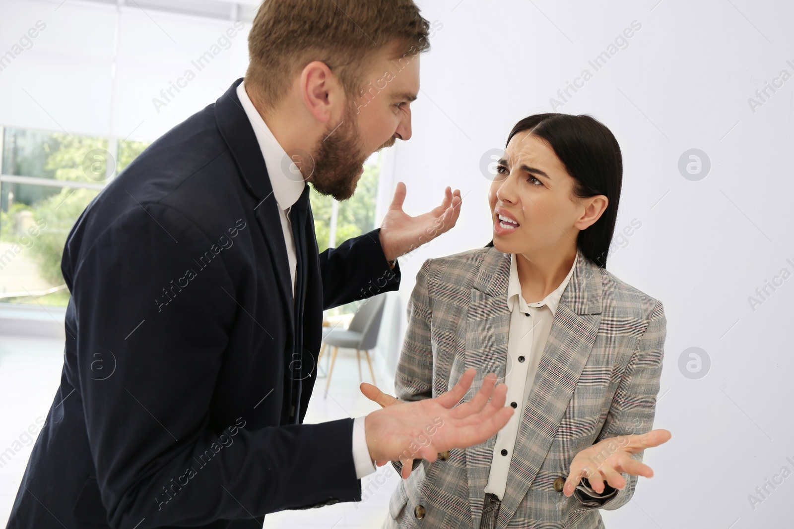 Photo of Man screaming at woman in office. Toxic work environment