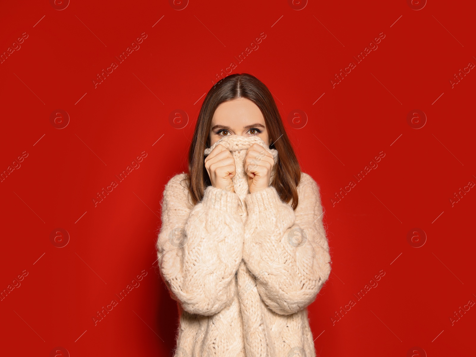 Photo of Young woman wearing Christmas sweater on red background