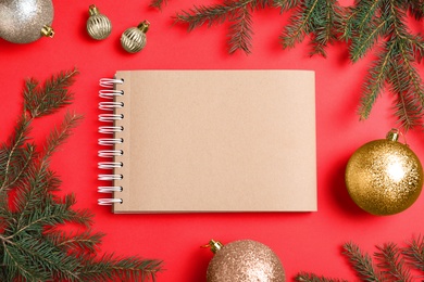 Flat lay composition with empty notebook and Christmas decorations on red background, space for text. Writing letter to Santa Claus