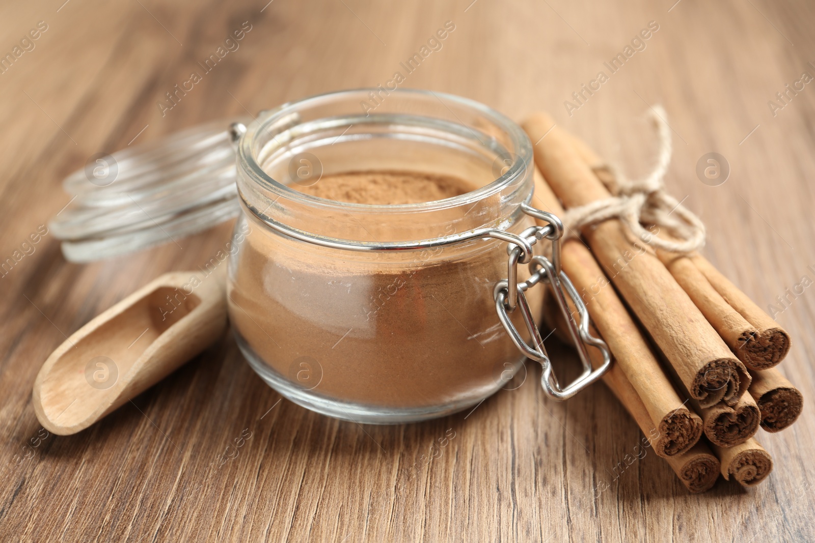 Photo of Cinnamon powder and sticks on wooden table