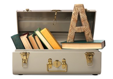 Photo of Stylish storage trunk with books and wooden letter A isolated on white