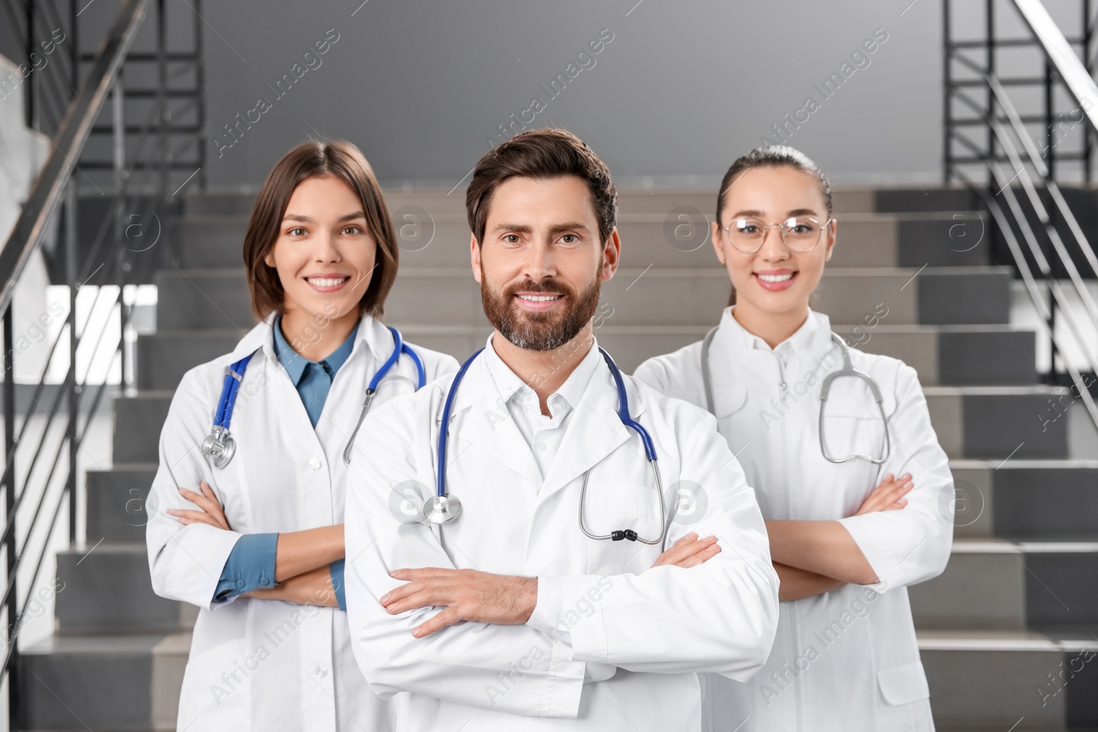 Photo of Team of professional doctors on staircase in clinic