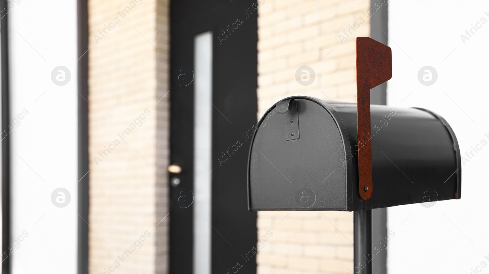 Photo of Black mailbox near house outdoors on sunny day