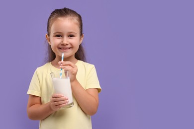 Cute girl with glass of fresh milk on violet background, space for text