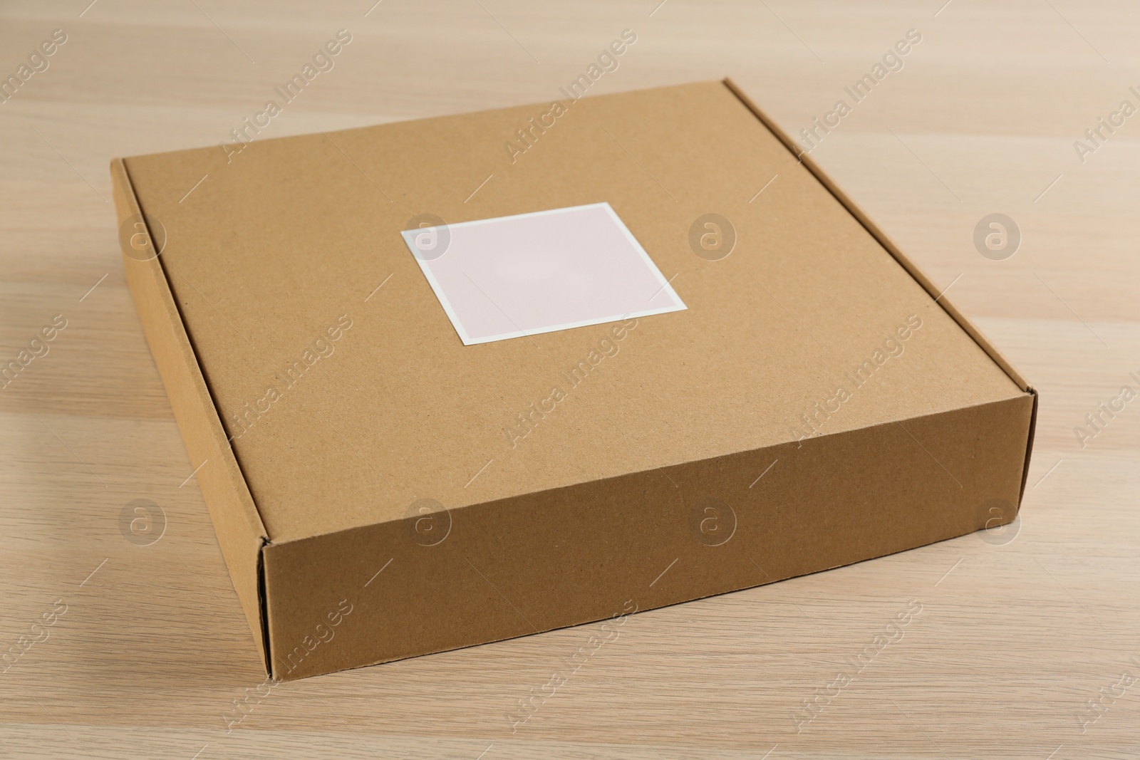 Photo of Closed cardboard box on wooden table, closeup