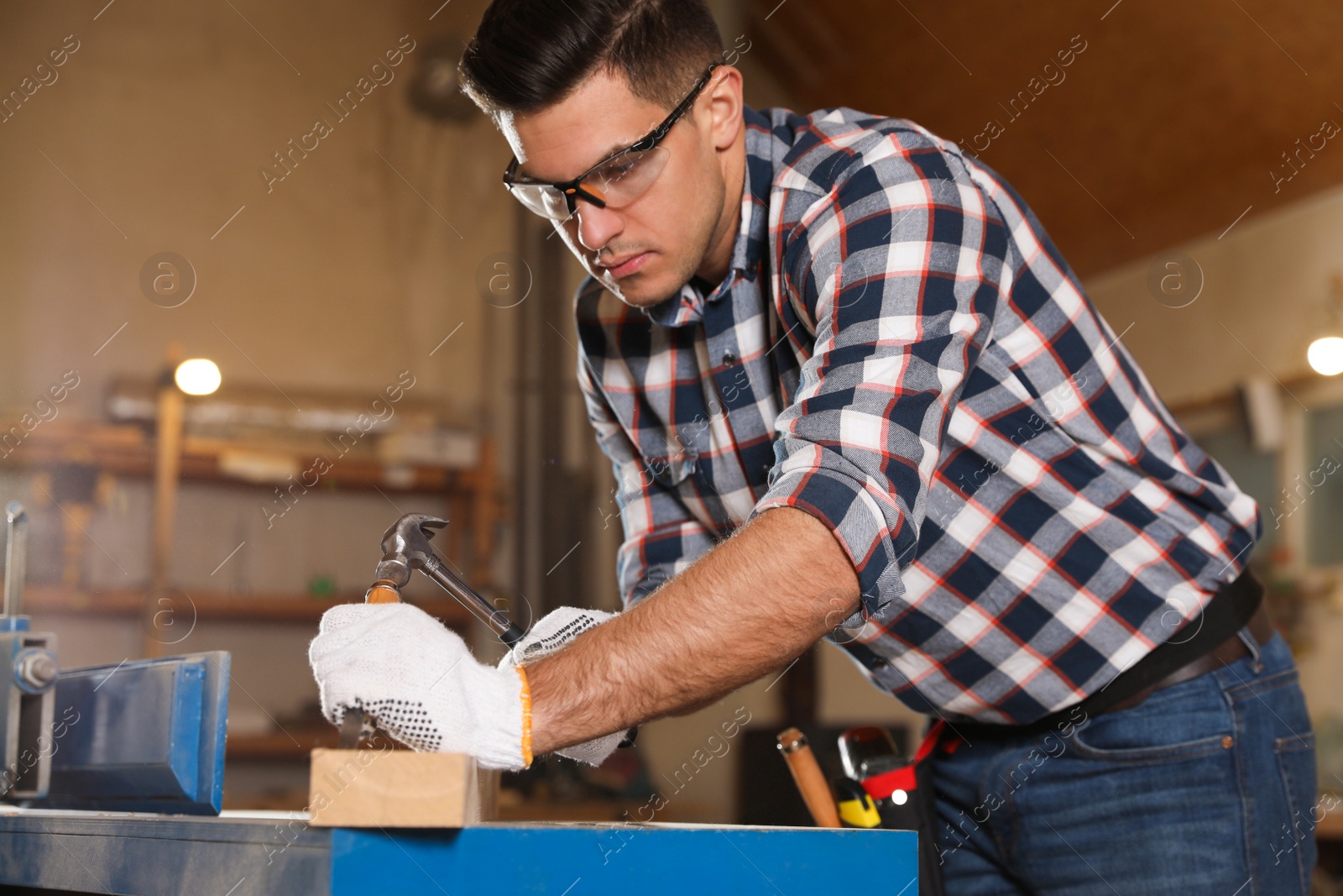 Photo of Professional carpenter working with wooden plank in workshop