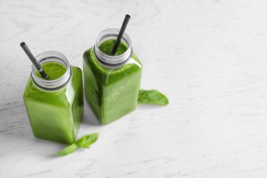 Photo of Bottles with delicious detox juice on light background