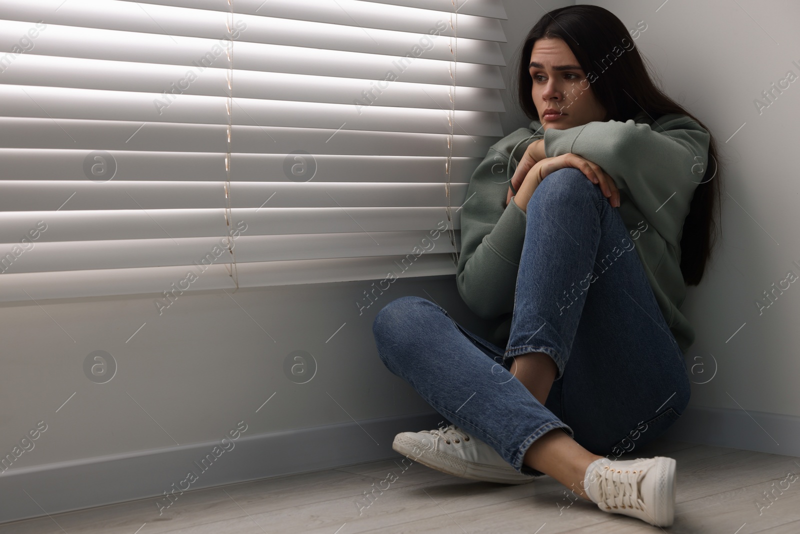 Photo of Sadness. Unhappy woman sitting on floor at home