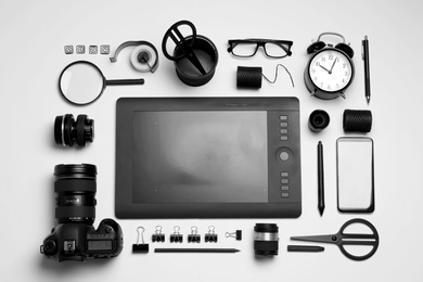 Photo of Flat lay composition with graphic drawing tablet and different office items on white background. Designer's workplace
