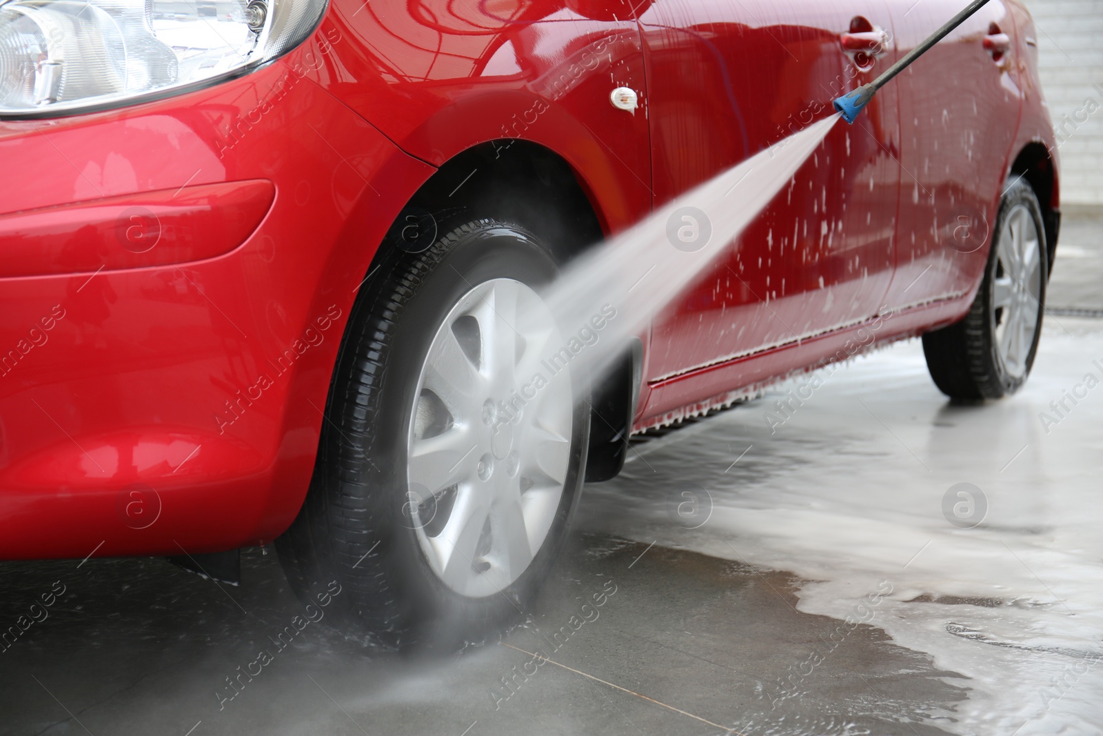 Photo of Cleaning vehicle with high pressure water jet at car wash