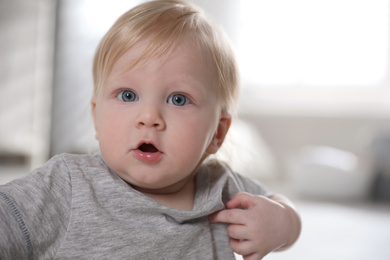 Photo of Adorable little baby on blurred background, closeup