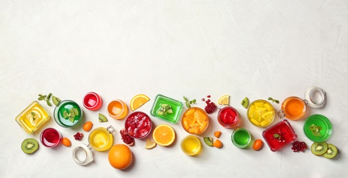 Photo of Flat lay composition with different jelly desserts on light background, space for text