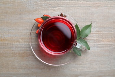 Aromatic rose hip tea and fresh berries wooden table, top view