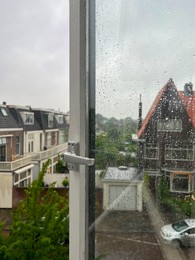 Photo of Beautiful cityscape with buildings on rainy day, view through open window