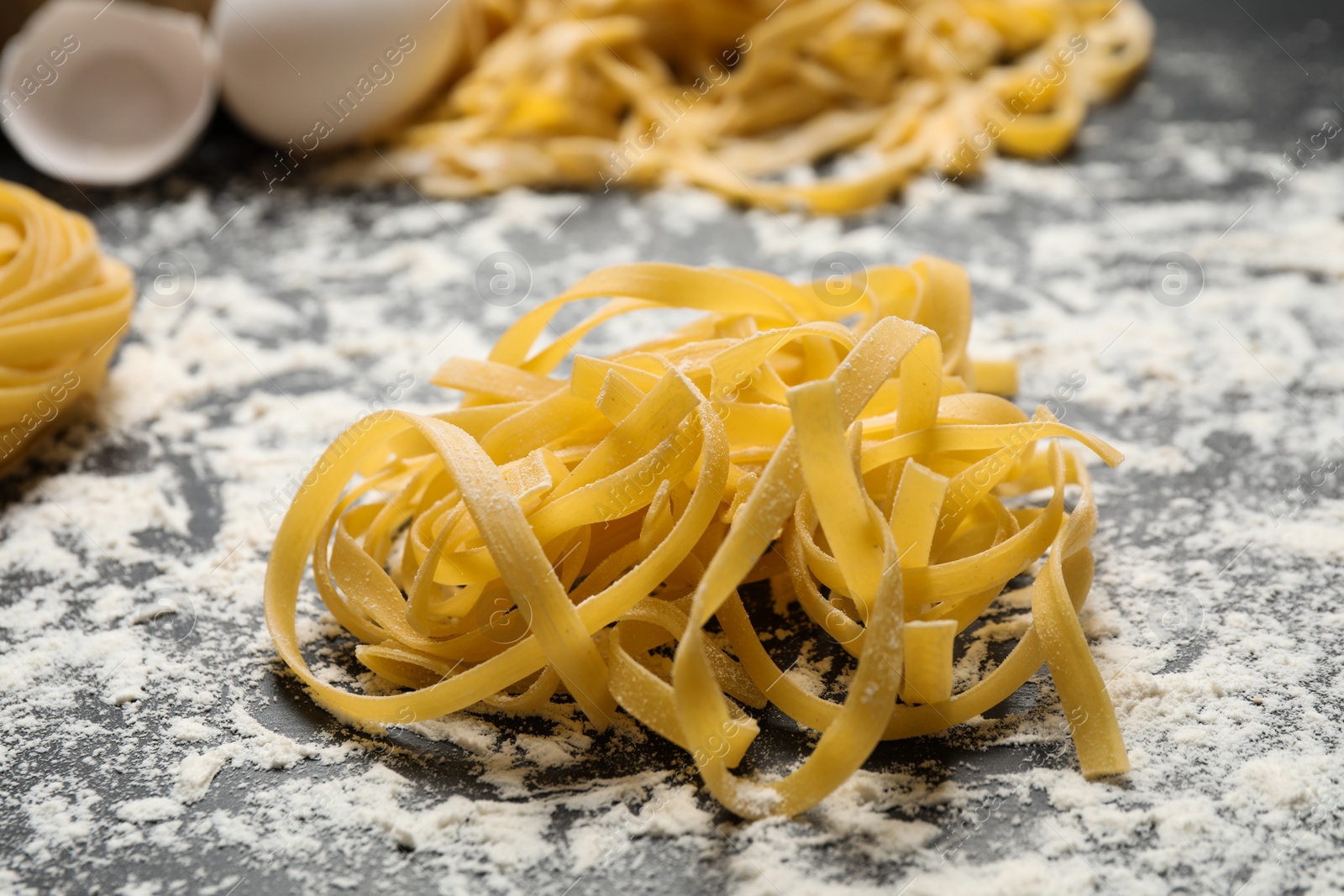 Photo of Tagliatelle pasta on grey table, closeup view