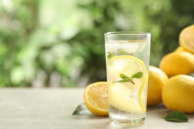 Cool freshly made lemonade and fruits on light table. Space for text