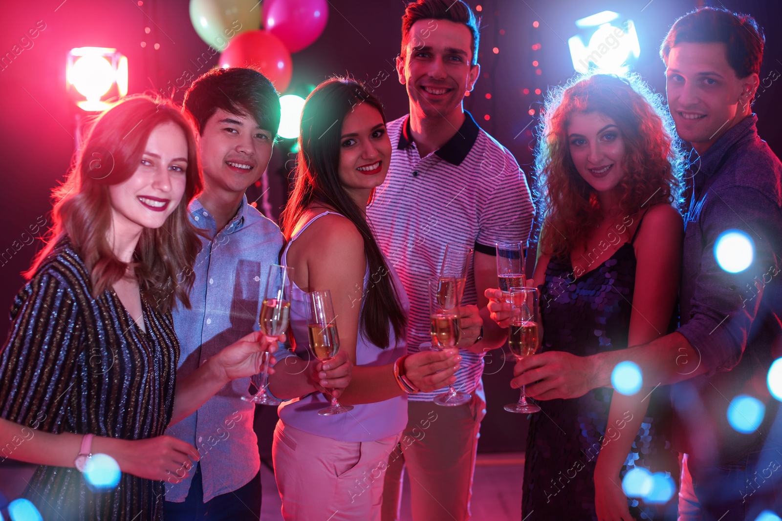 Photo of Young people celebrating birthday in nightclub
