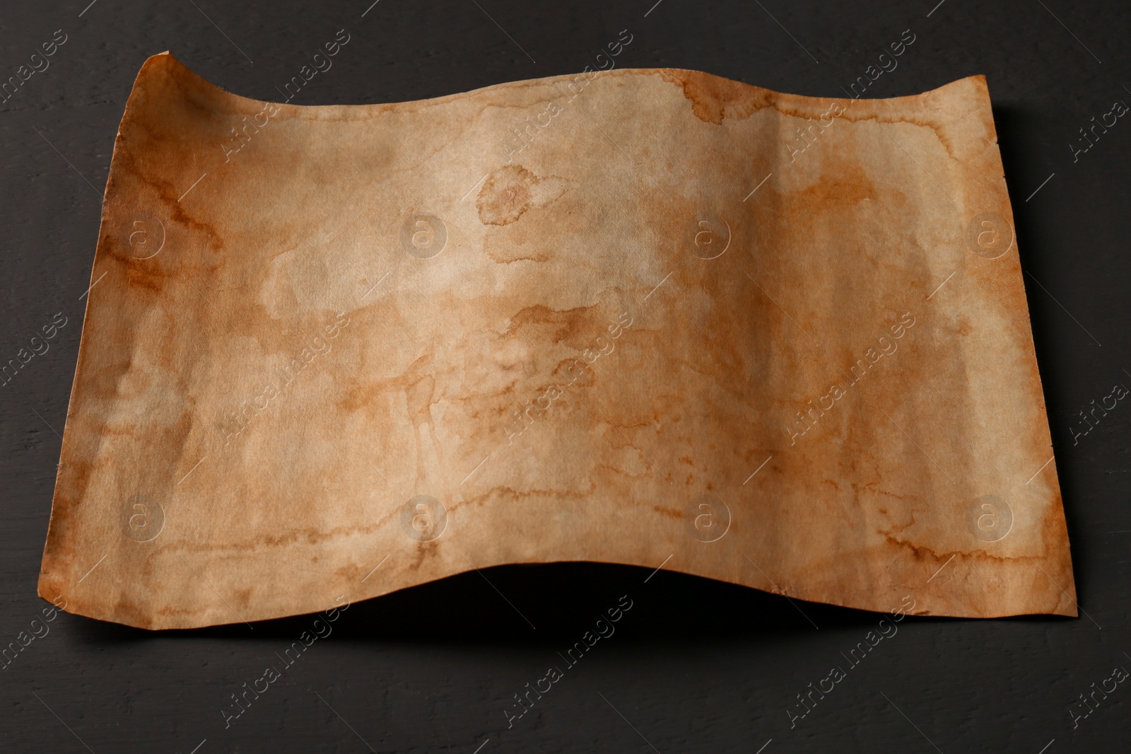 Photo of Sheet of old parchment paper on grey wooden table