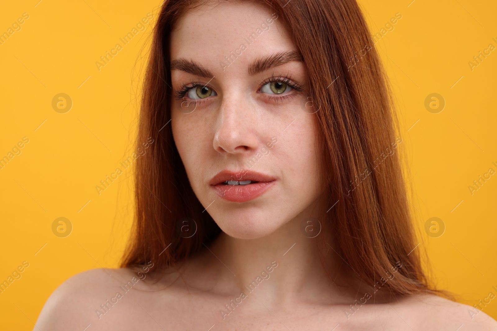 Photo of Portrait of beautiful woman with freckles on yellow background, closeup