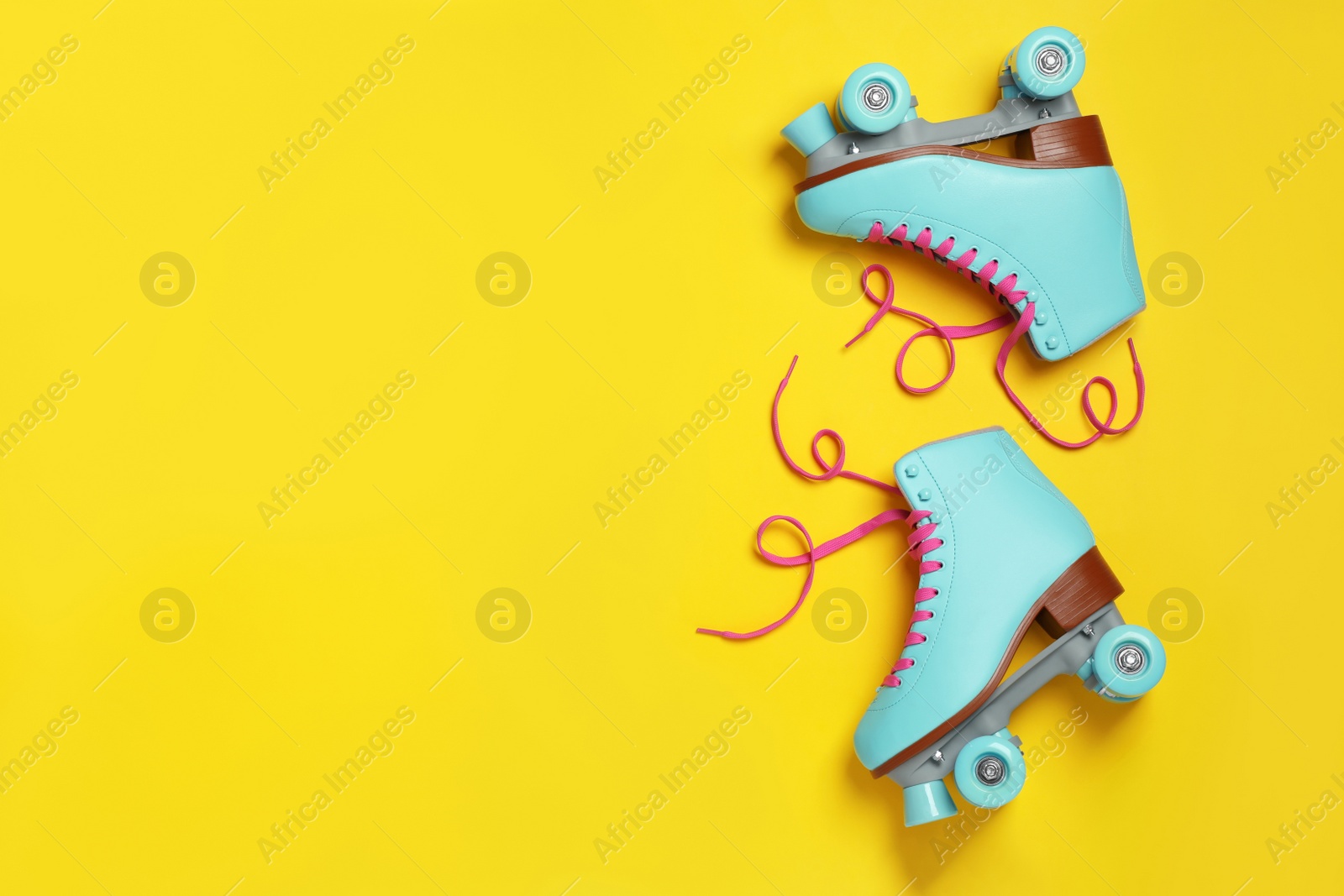 Photo of Pair of stylish quad roller skates on color background, top view with space for text