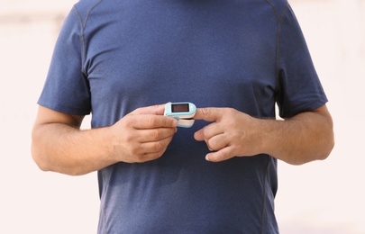 Photo of Man checking pulse outdoors on sunny day