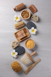 Photo of Flat lay composition with different spa products and flowers on light wooden table