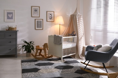 Photo of Baby room interior with comfortable crib and rocking chair