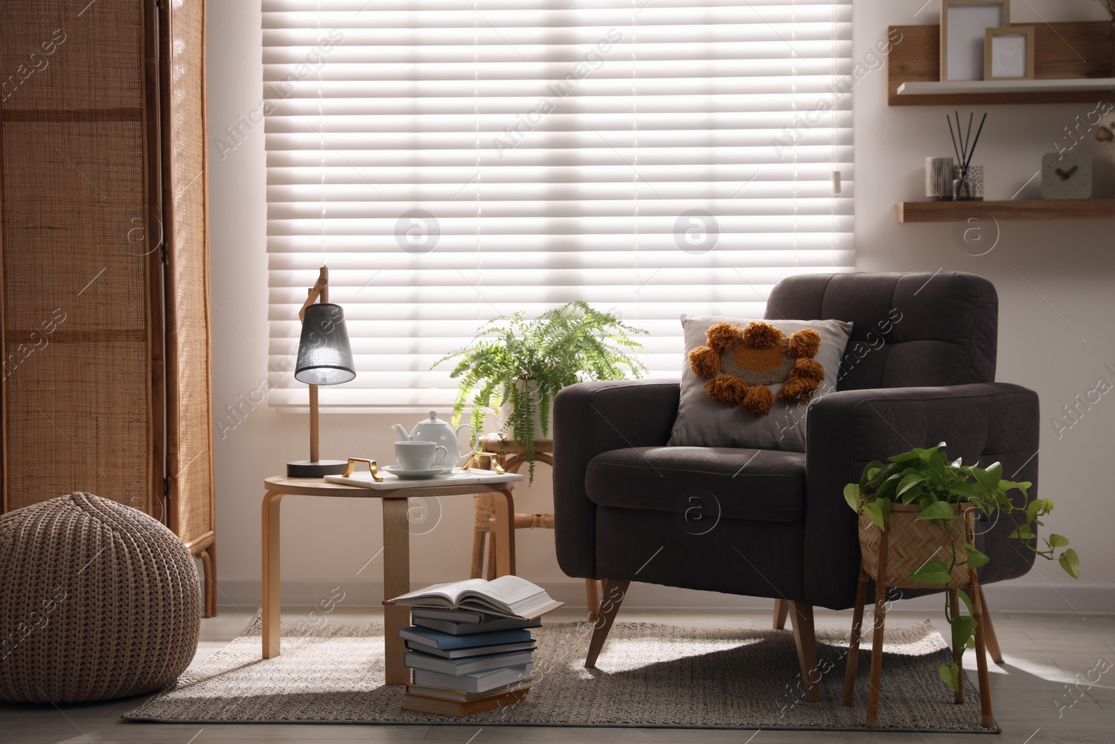 Photo of Comfortable place for rest with armchair near window in room