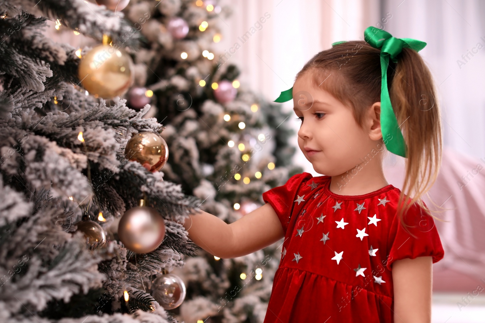 Photo of Cute little child near Christmas tree at home