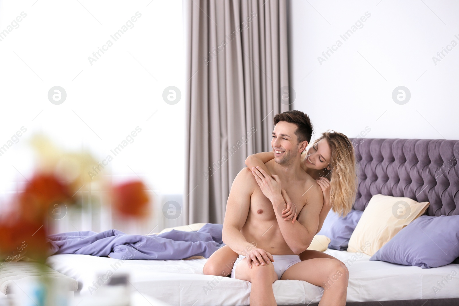 Photo of Sexy young couple being intimate on bed at home