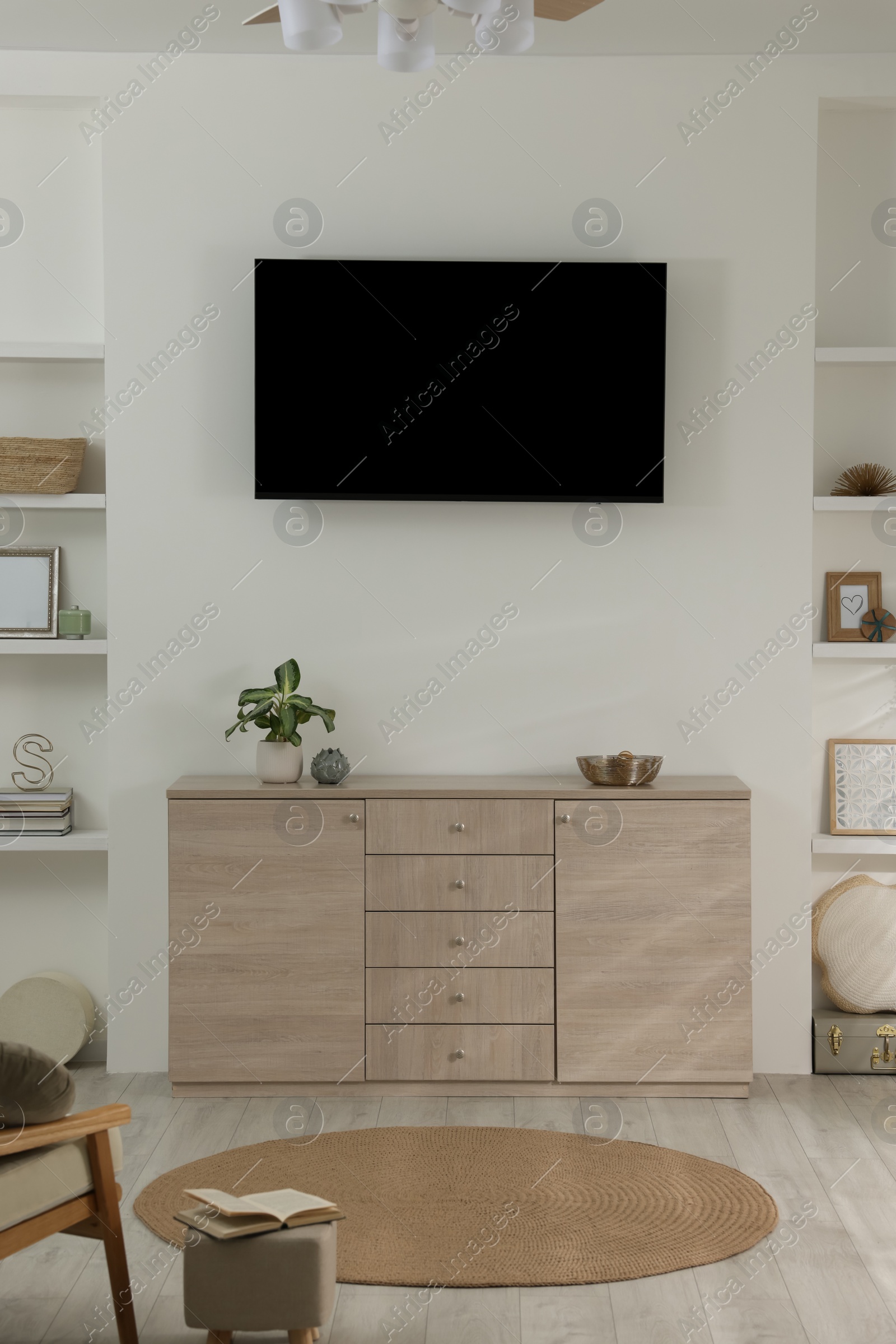 Photo of Stylish TV set mounted on wall in room