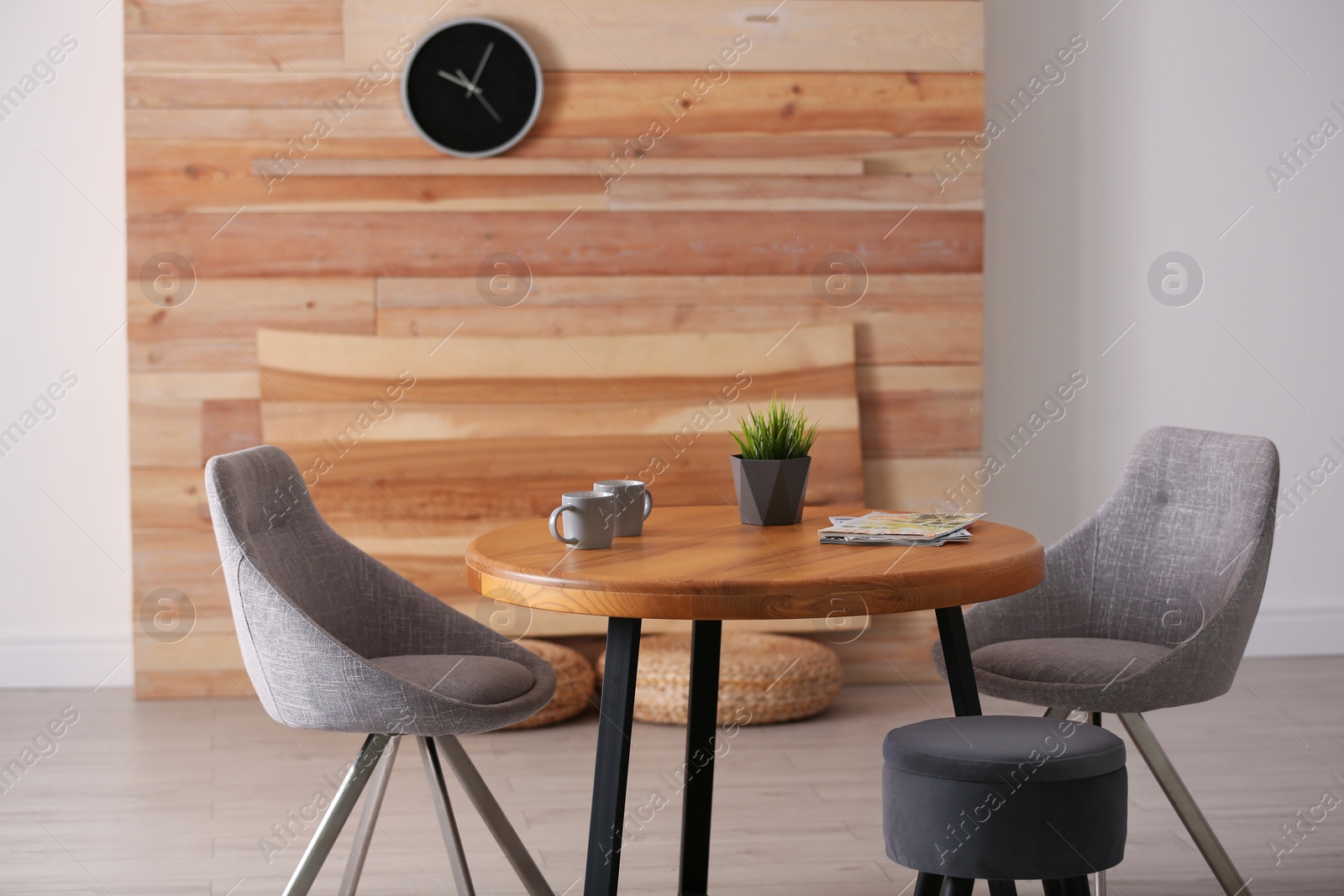 Photo of Stylish room interior with round table and comfortable chairs