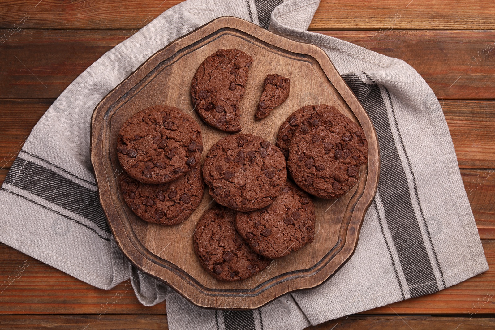 Photo of Board with tasty chocolate cookies on wooden table, top view