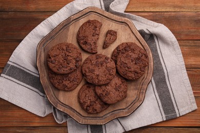 Photo of Board with tasty chocolate cookies on wooden table, top view