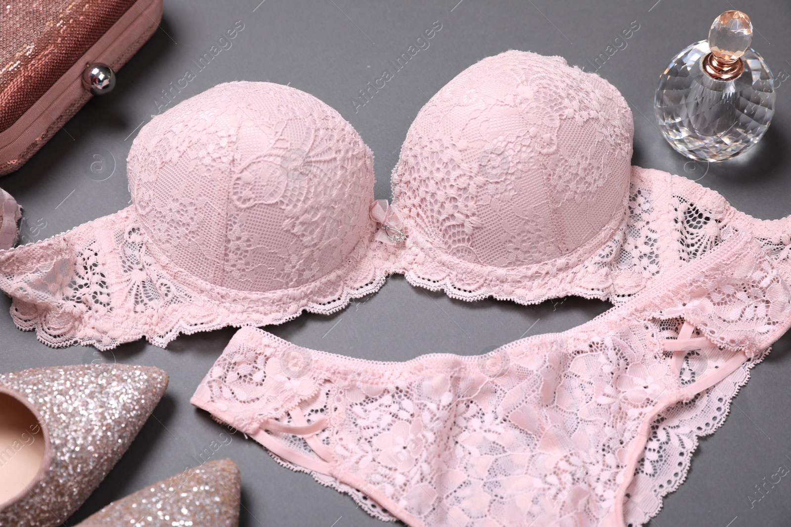 Photo of Elegant light pink women's underwear, perfume, clutch and shoes on grey background