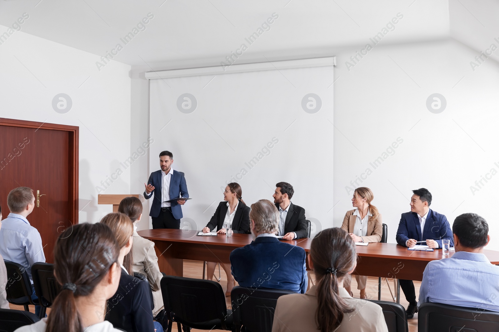 Photo of Business conference. People in meeting room listening to speaker report