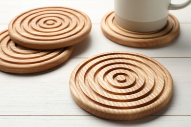 Stylish wooden cup coasters on white table