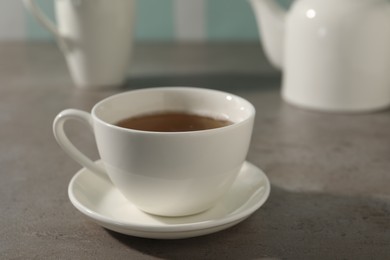 Photo of Aromatic tea in cup on gray table